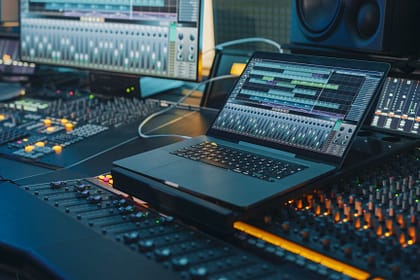 Modern Music Record Studio Control Desk with Laptop Screen Showing User Interface of Digital Audio Workstation Software. Equalizer, Mixer and Professional Equipment. Faders, Sliders. Record. Close-up – Foto- Adobe-Gorodenkoff